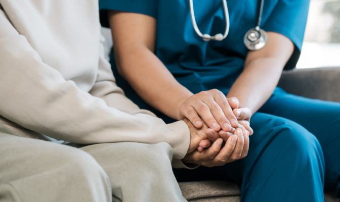 A Female Nurse Caregiver Holds Hands To Encourage And Comfort An Elderly Woman. For Care And Trust In Nursing Homes For People Of Retirement Age Caregiver Helping Elderly Woman Provides Medical Advice